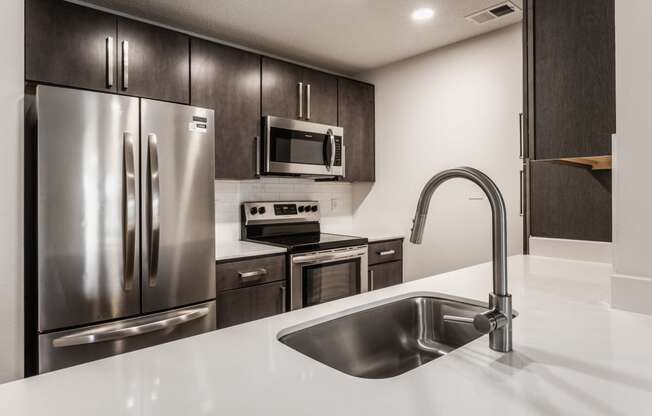 a kitchen with stainless steel appliances and a white counter top