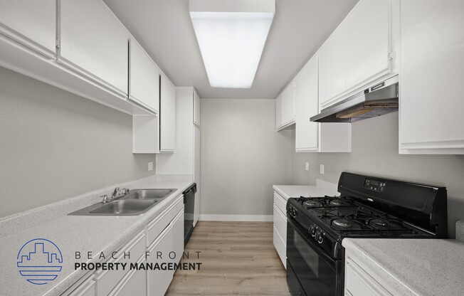 a kitchen with white cabinets and a stove and a sink