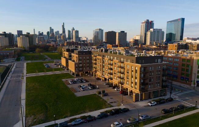 A cityscape with a mix of modern and older buildings, a parking lot in the foreground, and a clear sky.