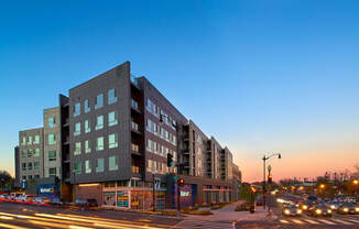 a large building on a city street at dusk