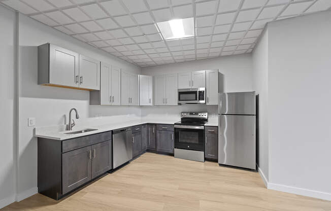 A kitchen with a refrigerator, oven, and sink.