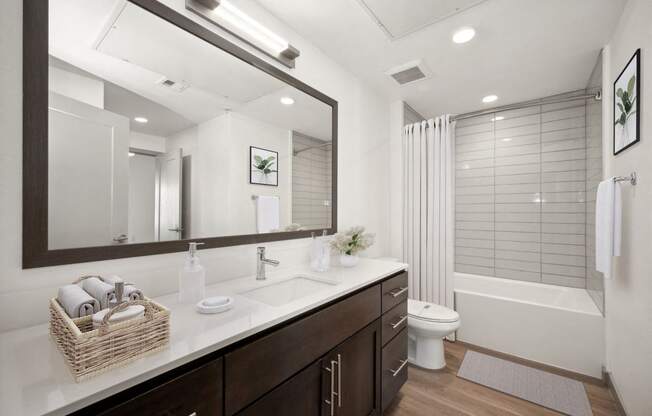 a bathroom with a large mirror and a toilet and a shower