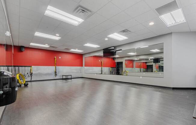 A large empty room with red walls and a grey floor.