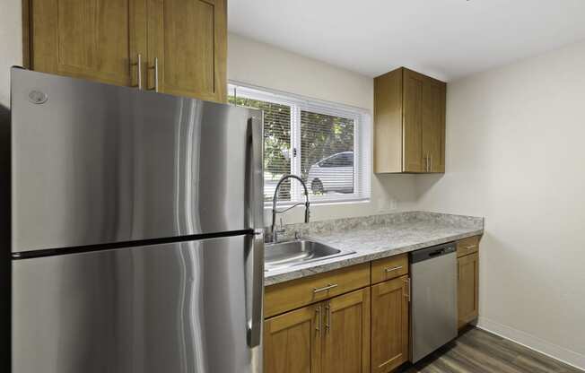 Kitchen with Wooden Cabinets and a Stainless Steel Refrigerator at Park 210 Apartment Homes, Edmonds, WA