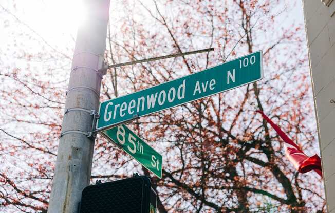 a street sign on the corner of greenwood avenue and 85th street