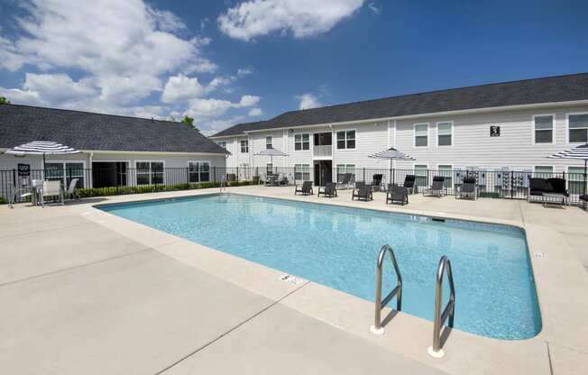 our apartments have a large swimming pool with chairs and umbrellas