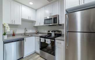 a kitchen with stainless steel appliances and white cabinets