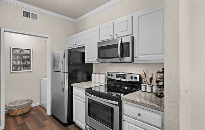 a kitchen with stainless steel appliances and white cabinets