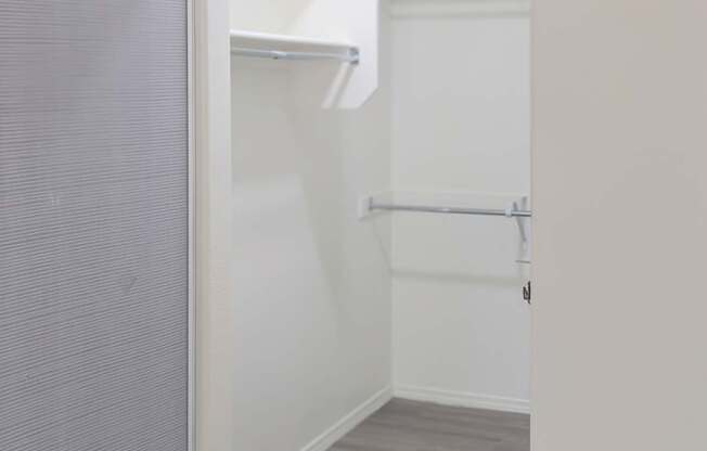 A white door is open to a hallway with a grey floor.