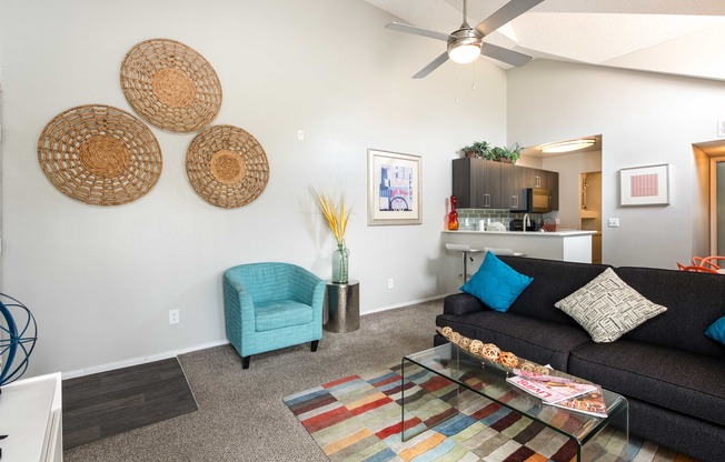 a living room with a couch and a chair and a ceiling fan