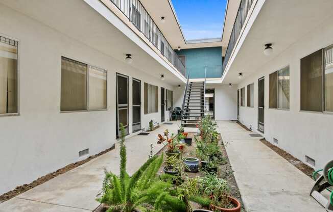 a courtyard with potted plants and a staircase