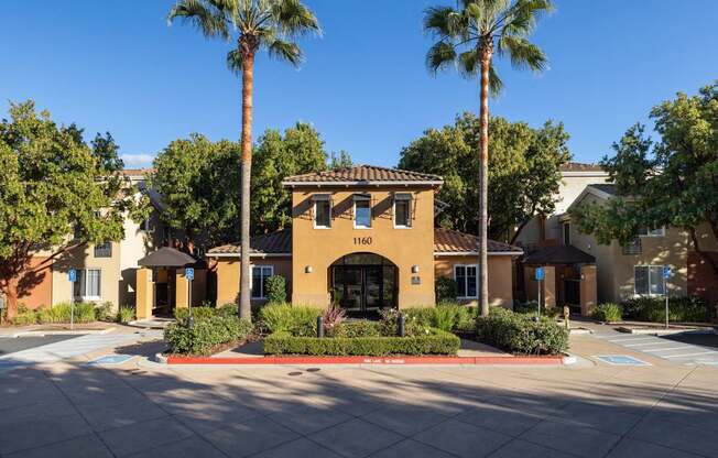 A building with the number 1160 on it is surrounded by palm trees.