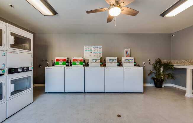 a kitchen with white appliances and a ceiling fan