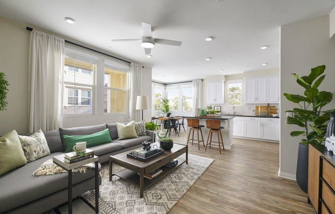 Apartments Riverside, CA - Living Room With Grey Couch, Wooden Coffee Table, And Patterned Area Rug