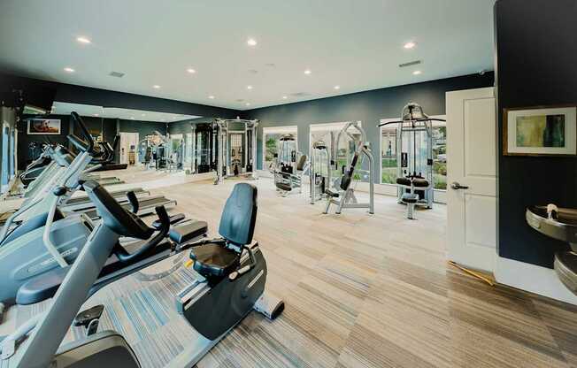 A gym with treadmills, elliptical machines, and other exercise equipment.
