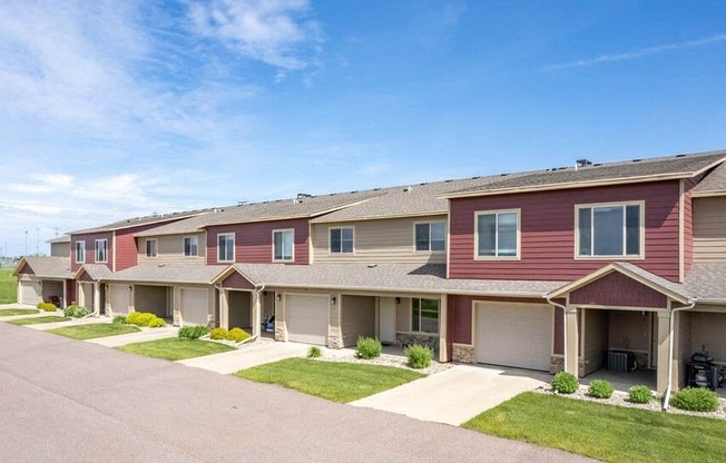 a row of townhomes on a street with grass
