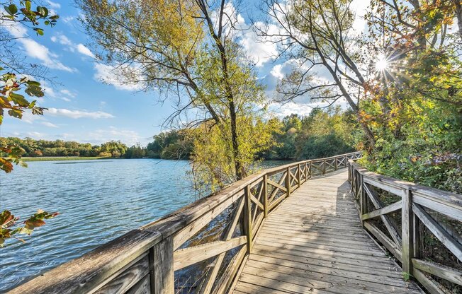 a wooden bridge over a lake on a sunny day