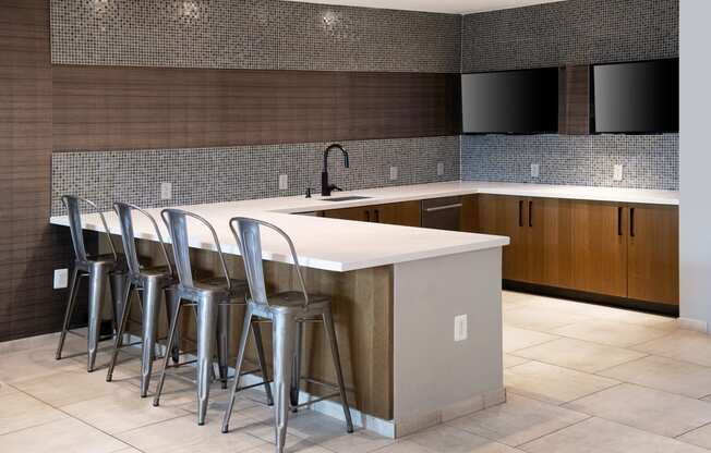 a kitchen with bar stools in front of a counter top