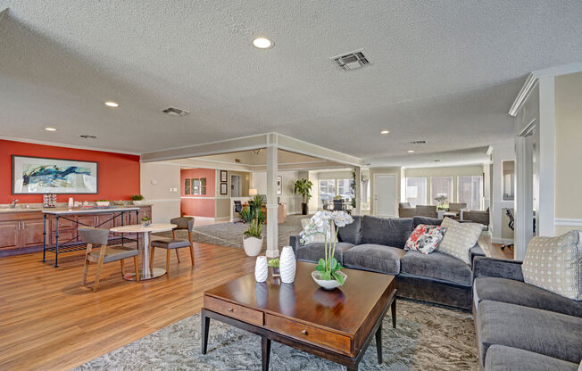 A stylish resident lounge at Acacia Park featuring modern seating, warm wood flooring, recessed lighting, flexible gathering areas, and a welcoming open layout ideal for relaxing, working, or socializing.