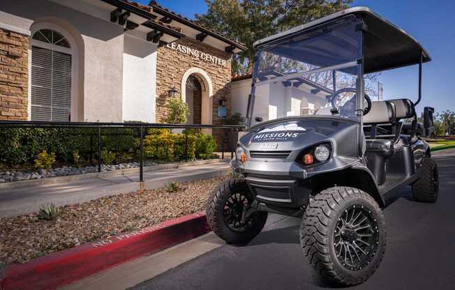 A golf cart is parked in front of a leasing center.