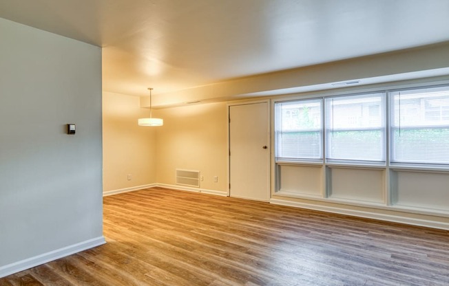 an empty living room with wood floors and windows at Gates of West Bay in Norfolk, Virginia 23503