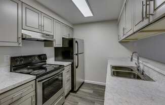 A kitchen with a stove, oven, and sink.