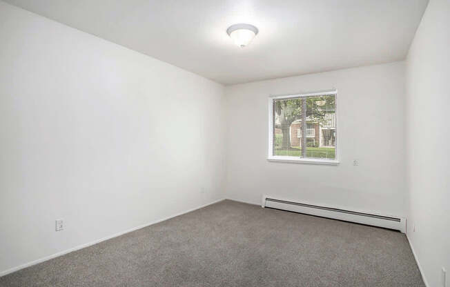 A spacious bedroom with a window at Brookside Apartments, Springfield