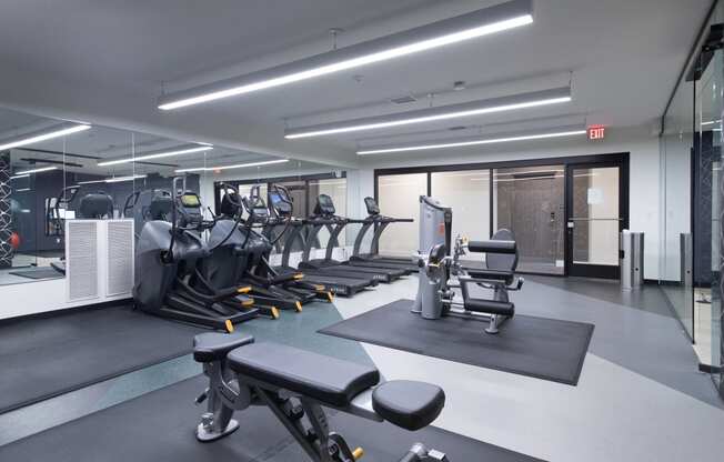 a gym with cardio equipment and weights