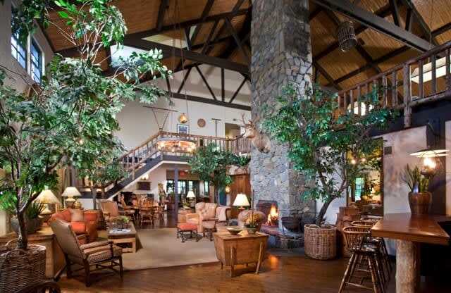 the lobby of a clubhouse with a large living room and a staircase