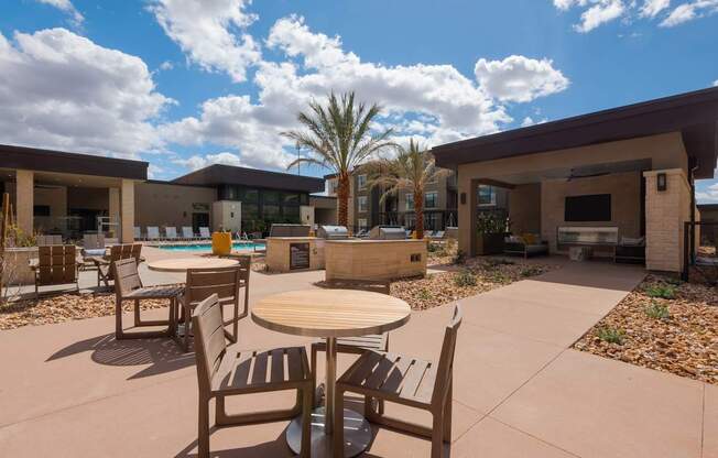 A patio with a table and chairs overlooking a pool.