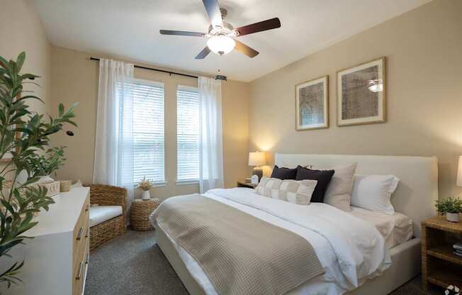 A bedroom with a large bed and a ceiling fan.