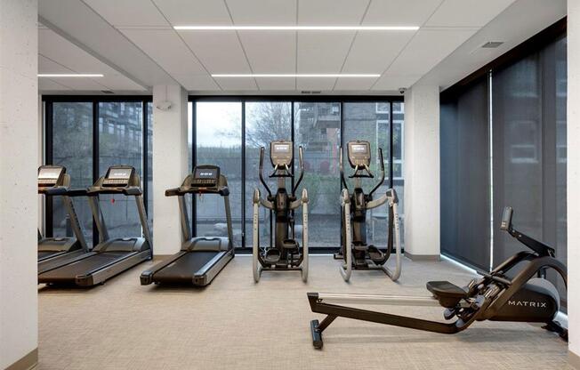 fitness center with cardio equipment and large windows