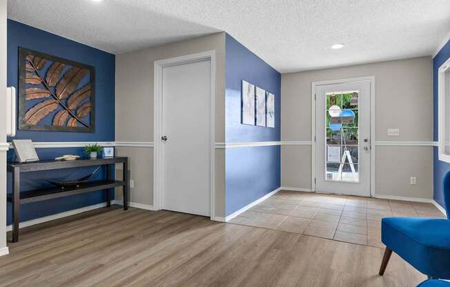 A room with a blue chair and a bed.