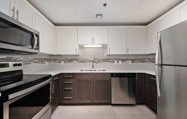 a kitchen with white cabinets and stainless steel appliances