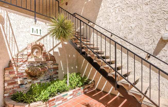 a set of stairs leading up to a building with a plant