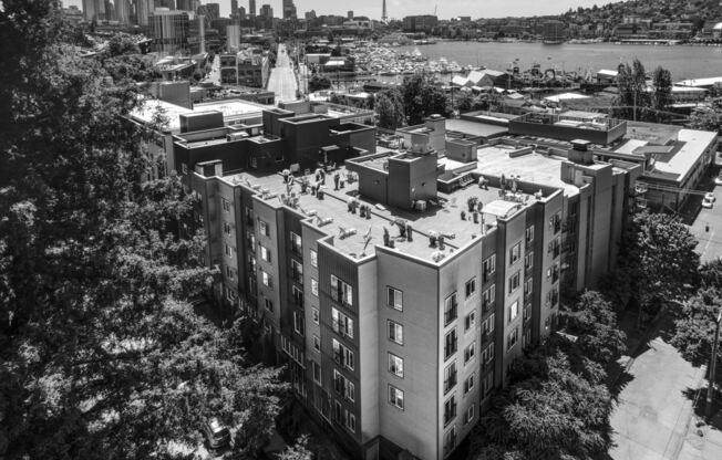 a black and white photo of an apartment building with people on it