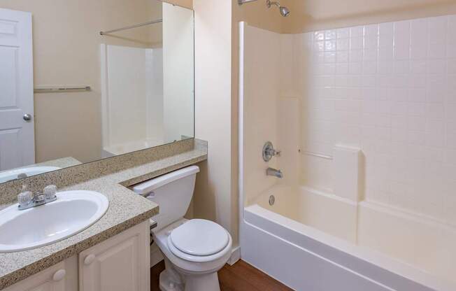 A white toilet sits next to a sink in a bathroom.