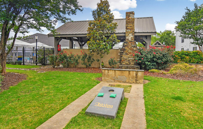 a park with a fountain and a house in the background at Avalon Apartment Homes, Starkville, 39759