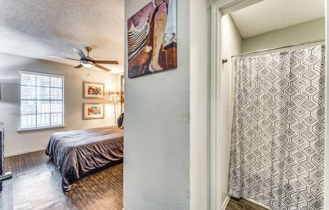 the master bedroom has a ceiling fan and a sliding door to the bathroom