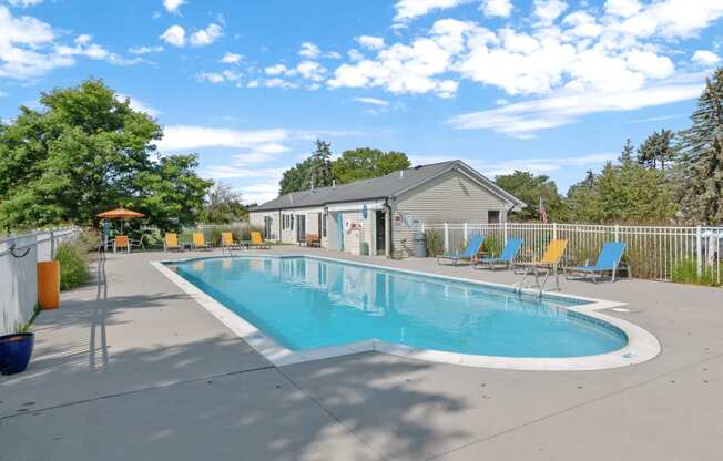 a swimming pool with lounge chairs and a building in the background