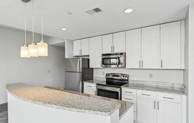 a kitchen with white cabinets and granite counter tops