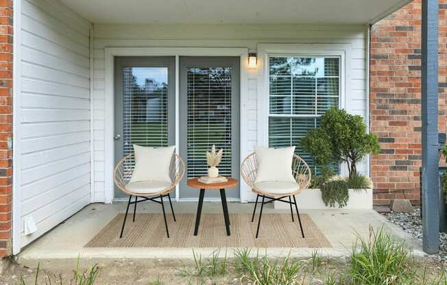 A patio with two chairs and a table.
