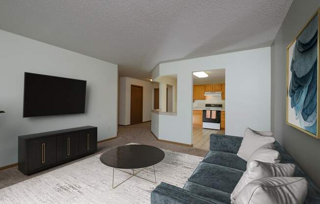 A living room with a couch and a coffee table. Fargo, ND Pinehurst Apartments.