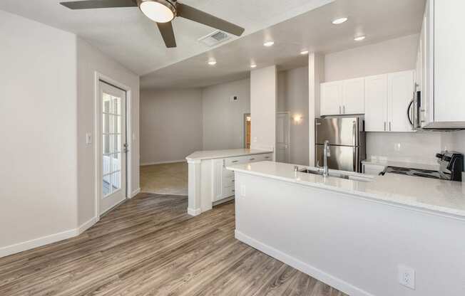 Open Kitchen with Wood Inspired Floors, Ceiling Fan/Light, White Counter and Refrigerator