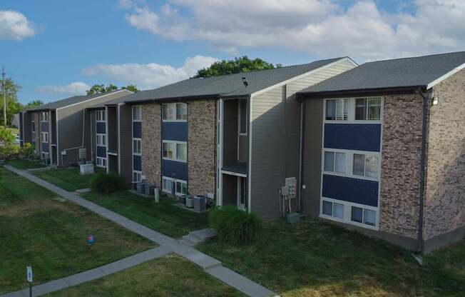 Apartment complex with a grassy area in front.