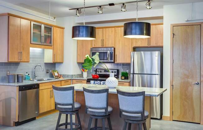 A kitchen with a table and chairs in the middle.