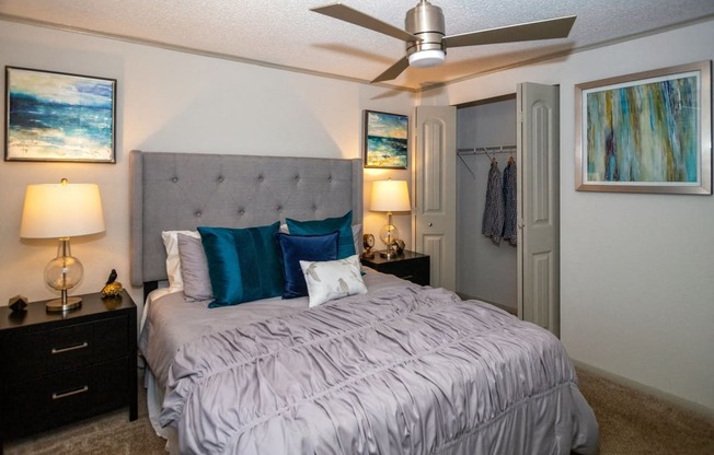 Bedroom in the Retreat at Indian Lake in Hendersonville with modern ceiling fan and queen bed with fabric headboard and luxury duvet and velvet pillows.