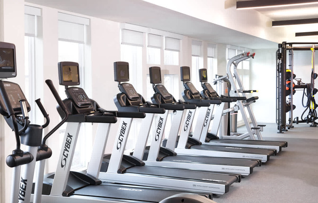 a row of cardio machines in a gym