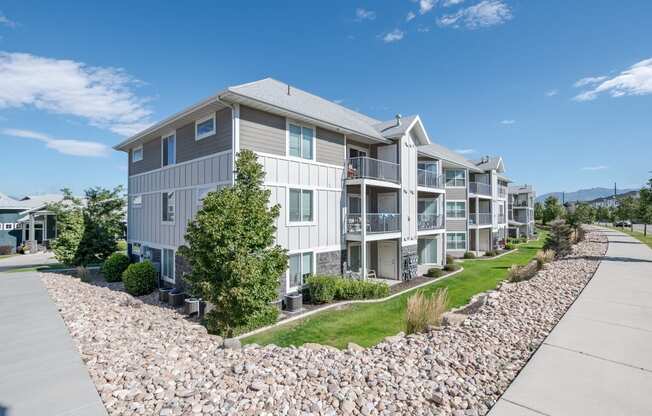 an exterior view of an apartment building with a gravel pathway