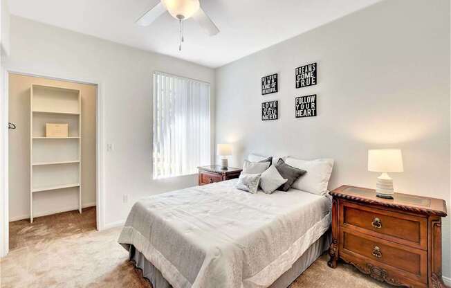 A bedroom with a bed, dresser, and a ceiling fan.